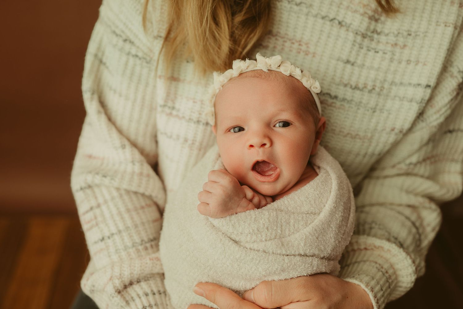 Baby girl yawns during studio newborn photography session at Disney Magic Photography studio in Clarksville, Tennessee