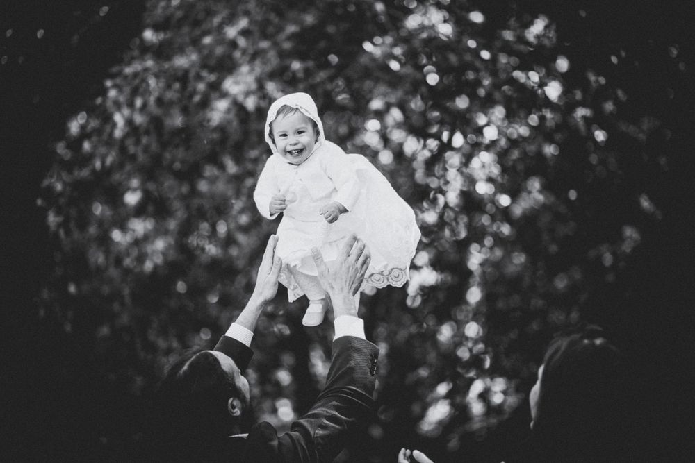 Menina no seu dia do batizado com os pais