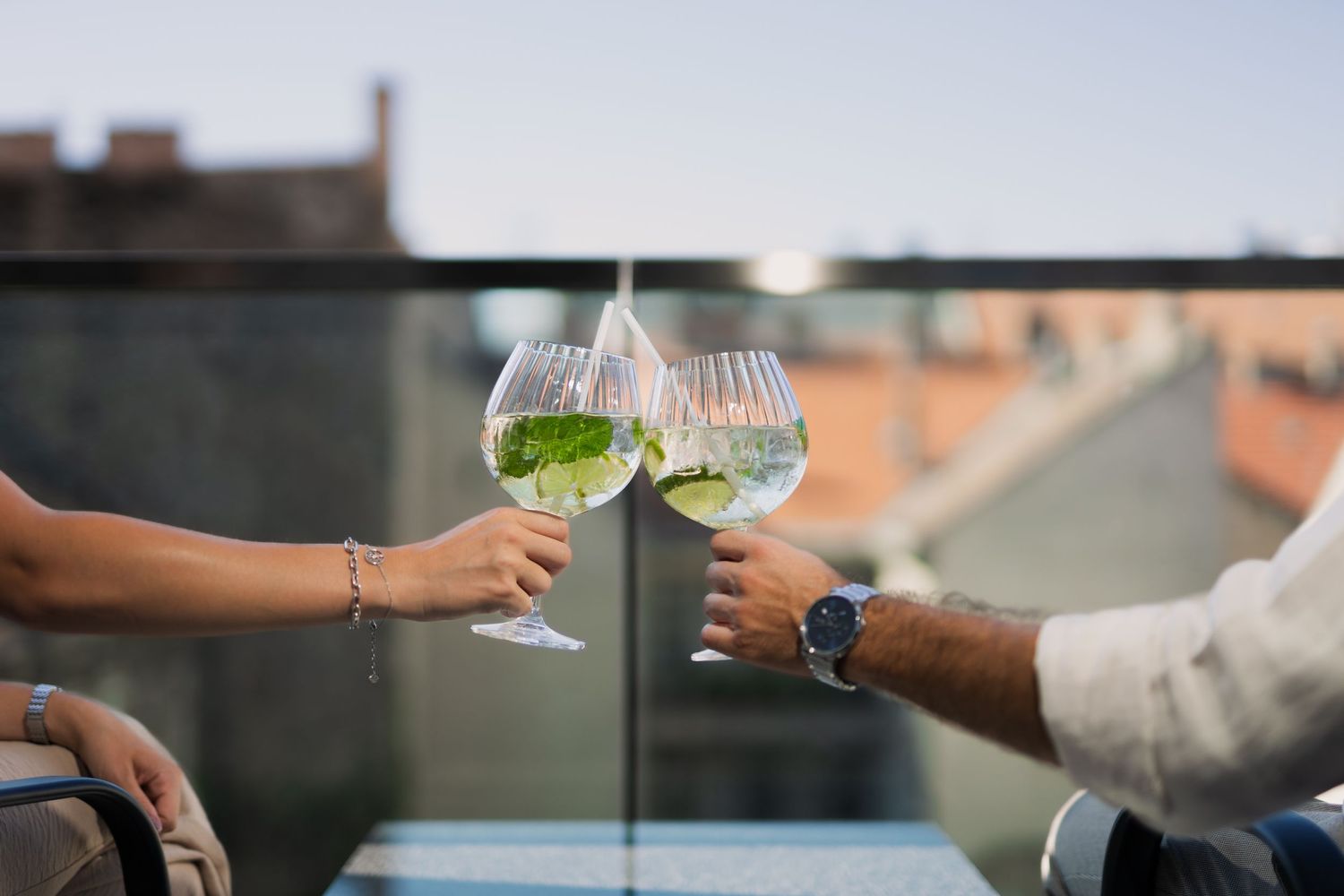 Koccintás egy tetőteraszon, városi háttérrel – hangulatos lifestyle jelenet, ideális gasztro vagy rendezvényhelyszín bemutatására.
