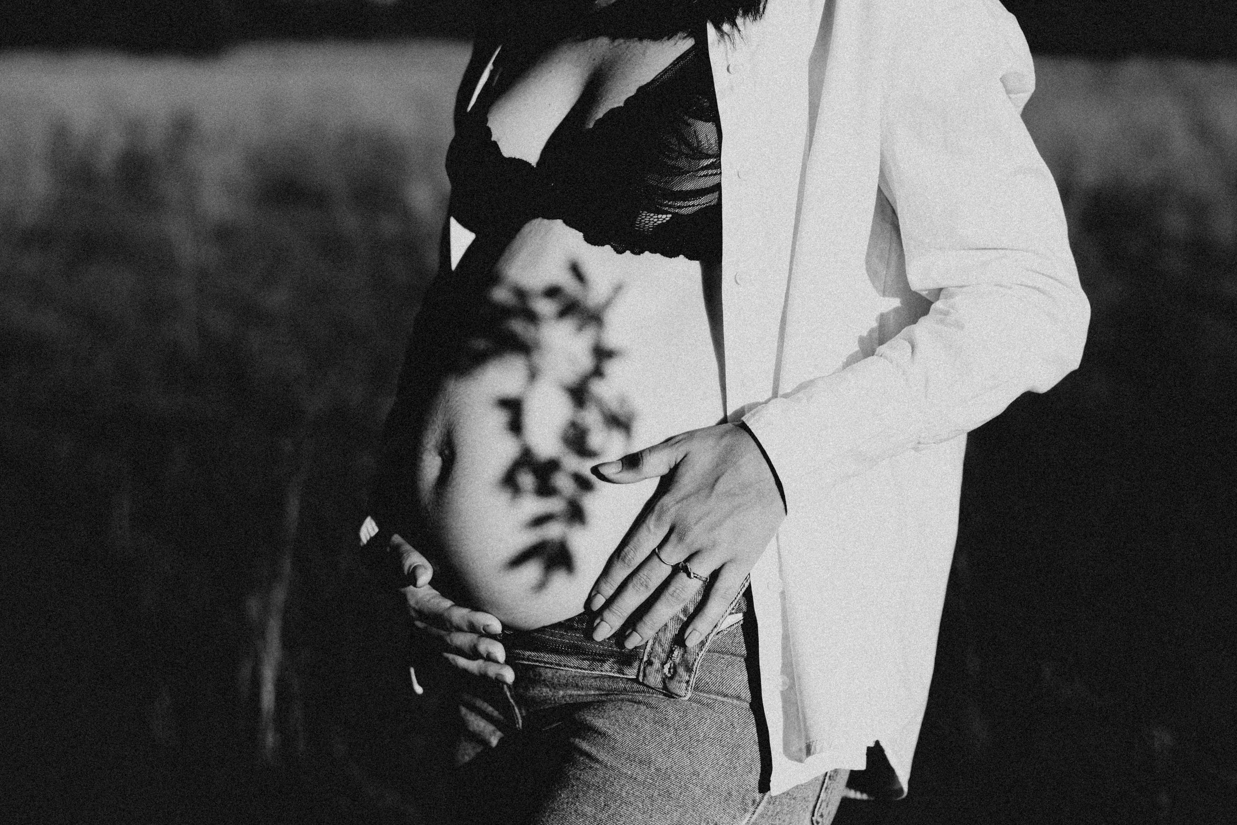 Artistic black and white maternity photo with shadows and white blazer.