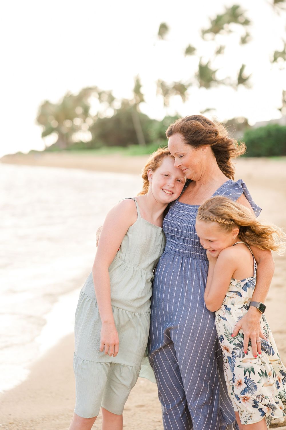 A family shares joyful moments together while walking on a sandy beach at sunset.