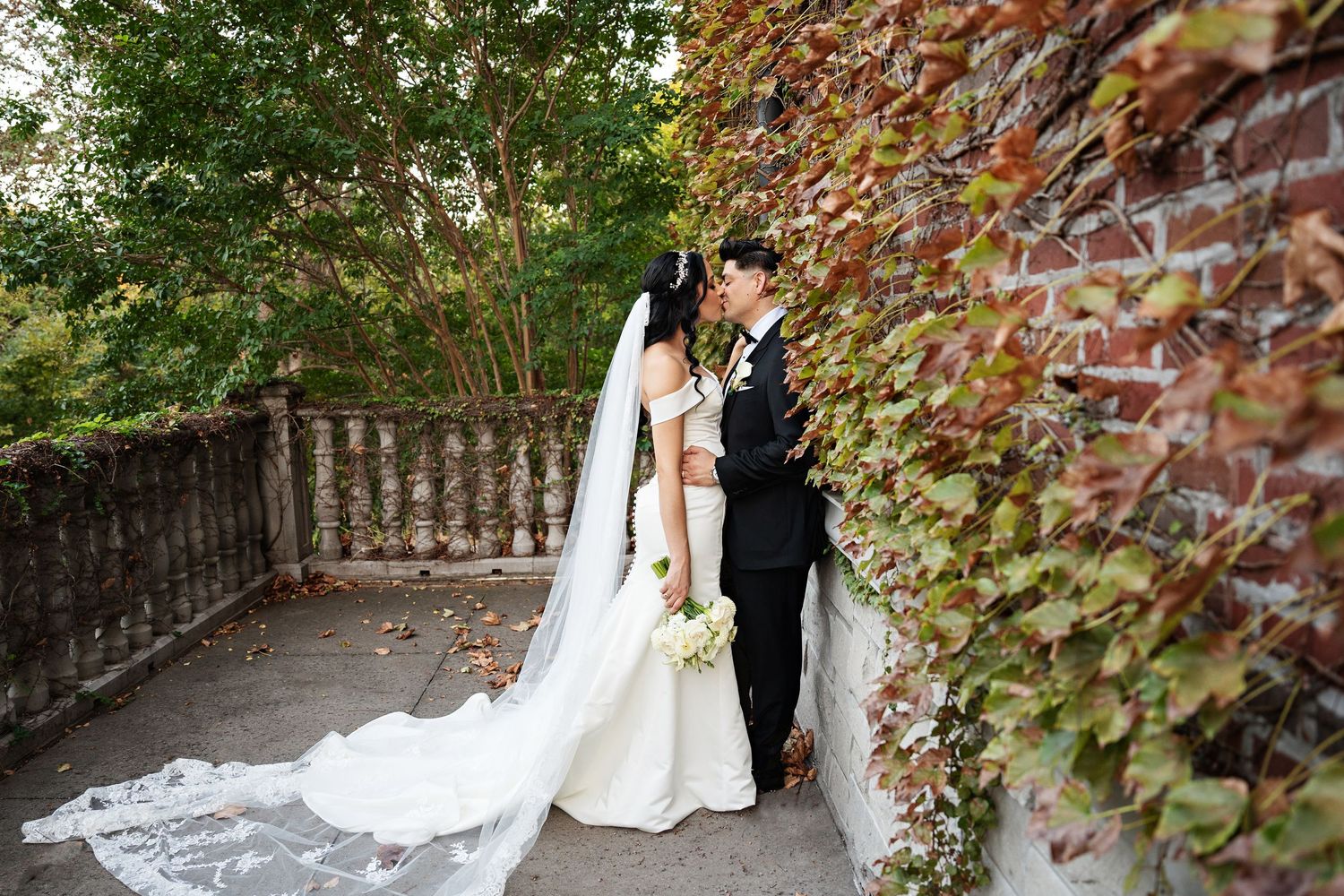 bride and groom kissing among the foliage