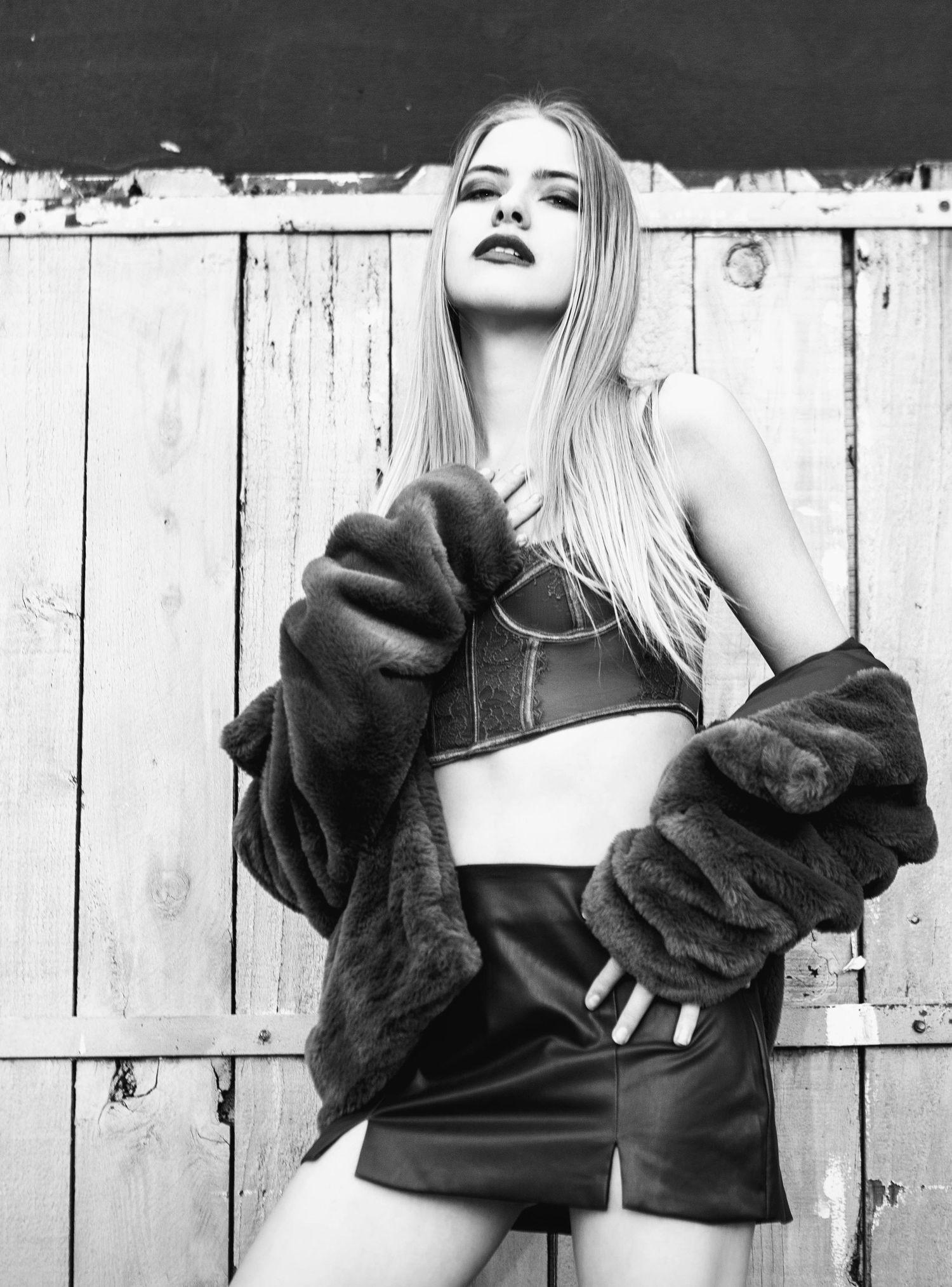 Black and white image of striking blonde model in camisole and miniskirt. high-fashion lifestyle.