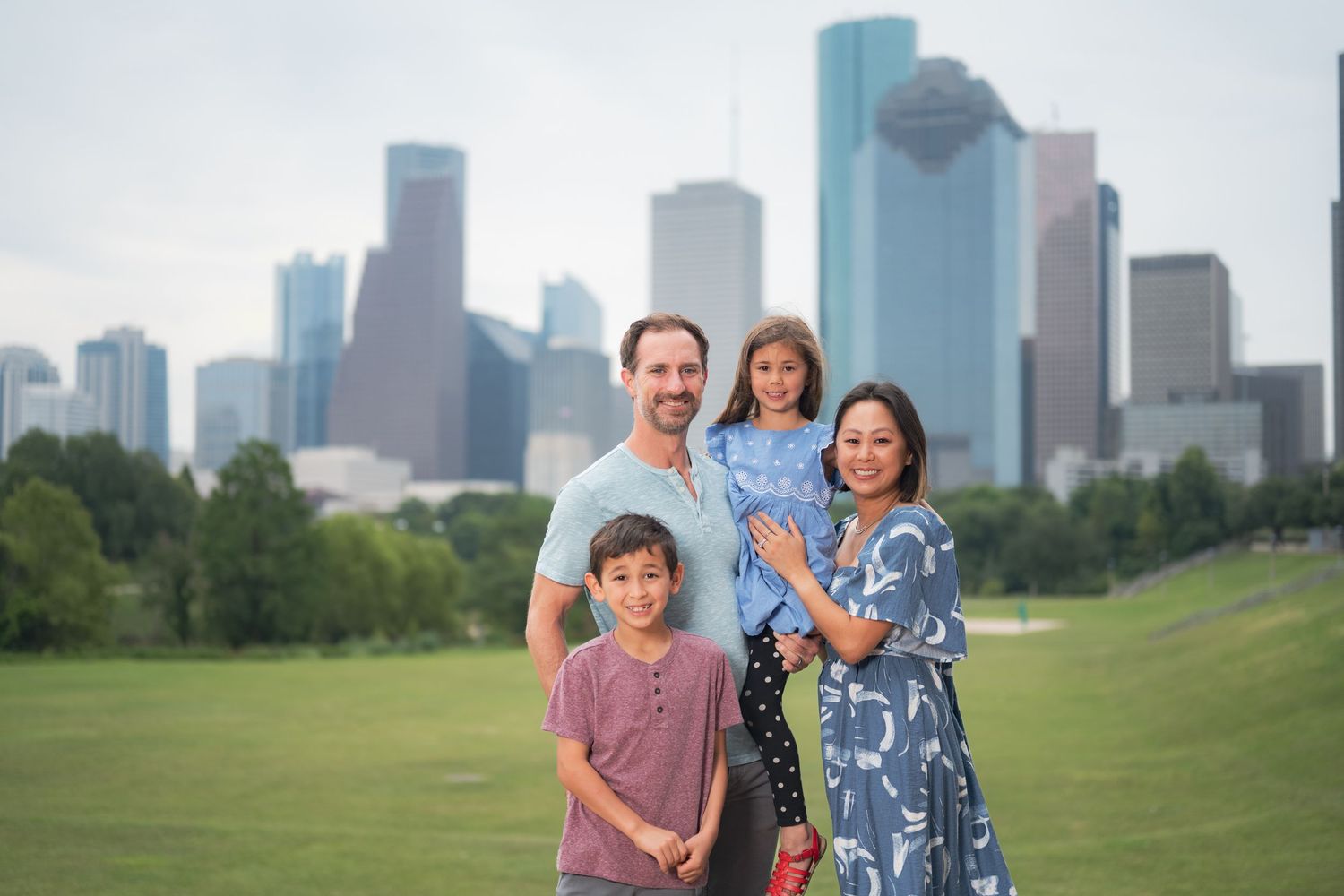 Group photo with Houston skyline and green park in the background.