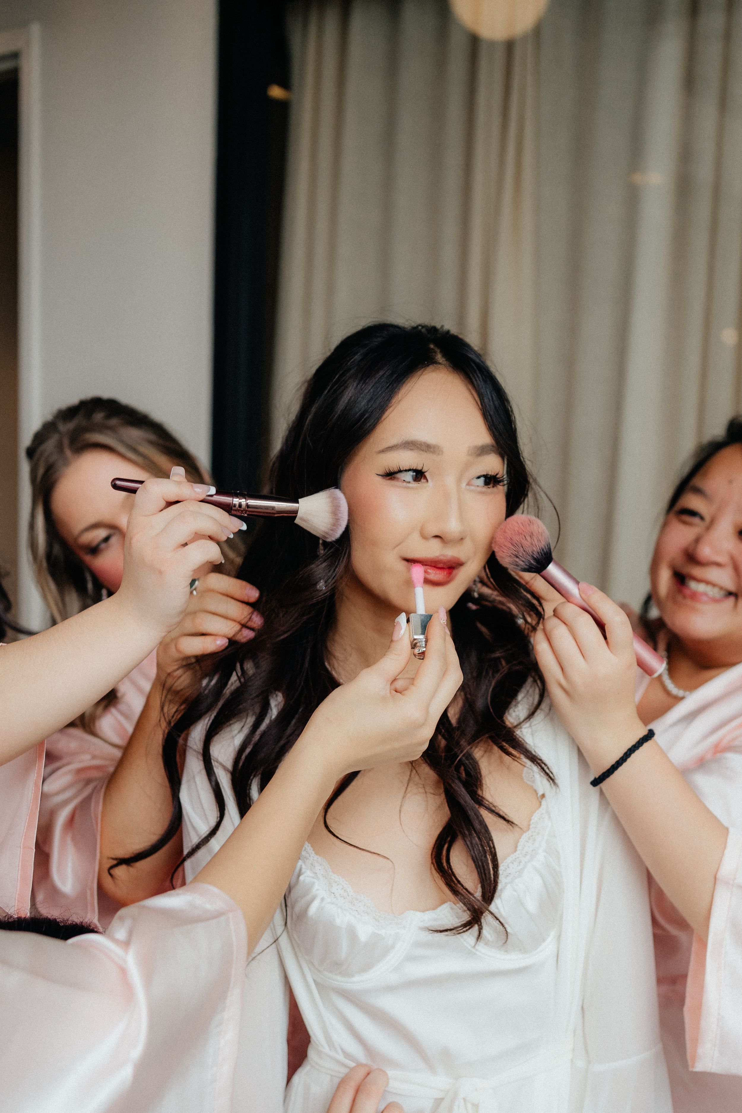 Wedding preparation scene showing makeup application with brushes and beauty tools.