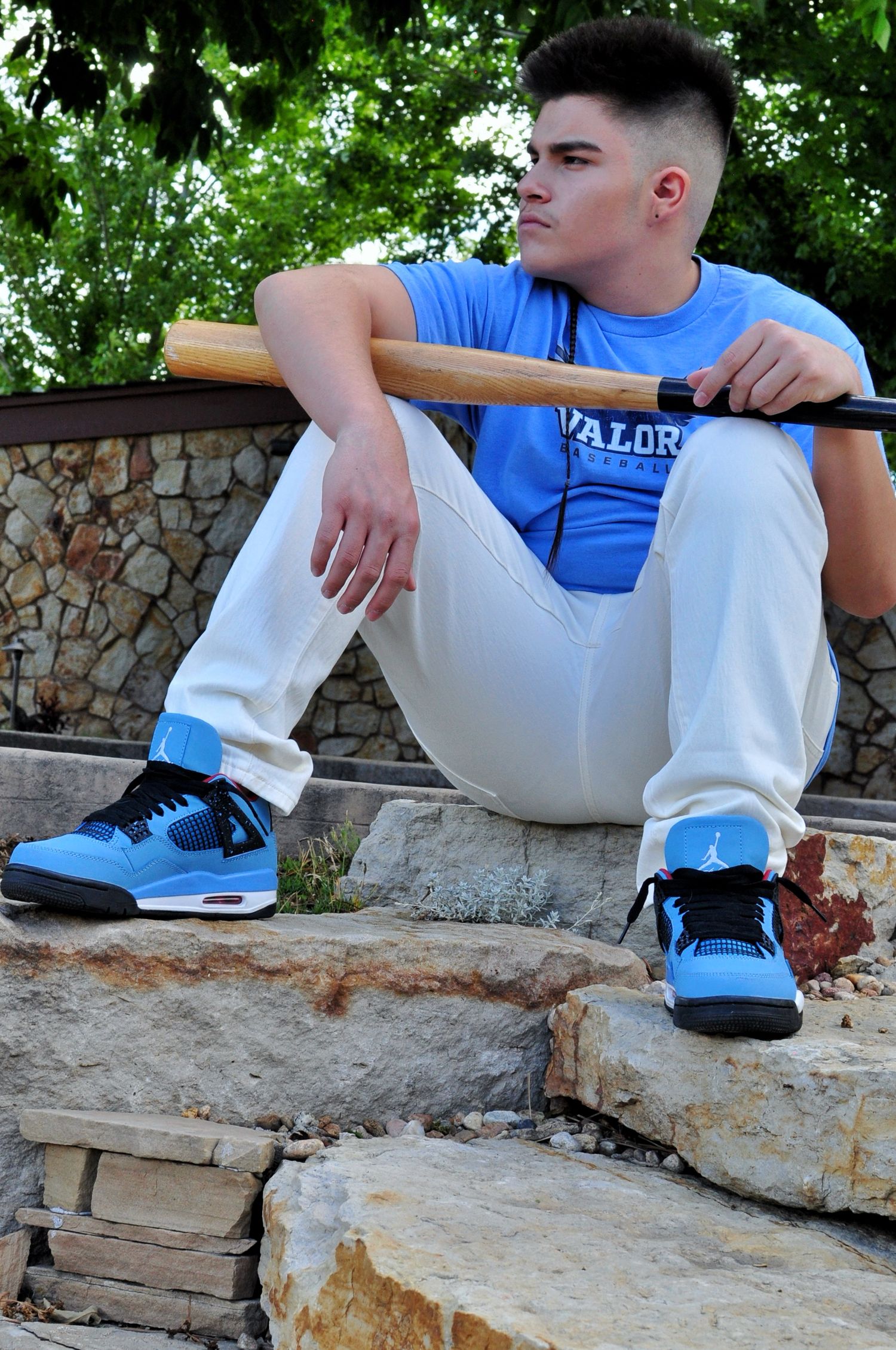 Young man, seated, holding a baseball bat