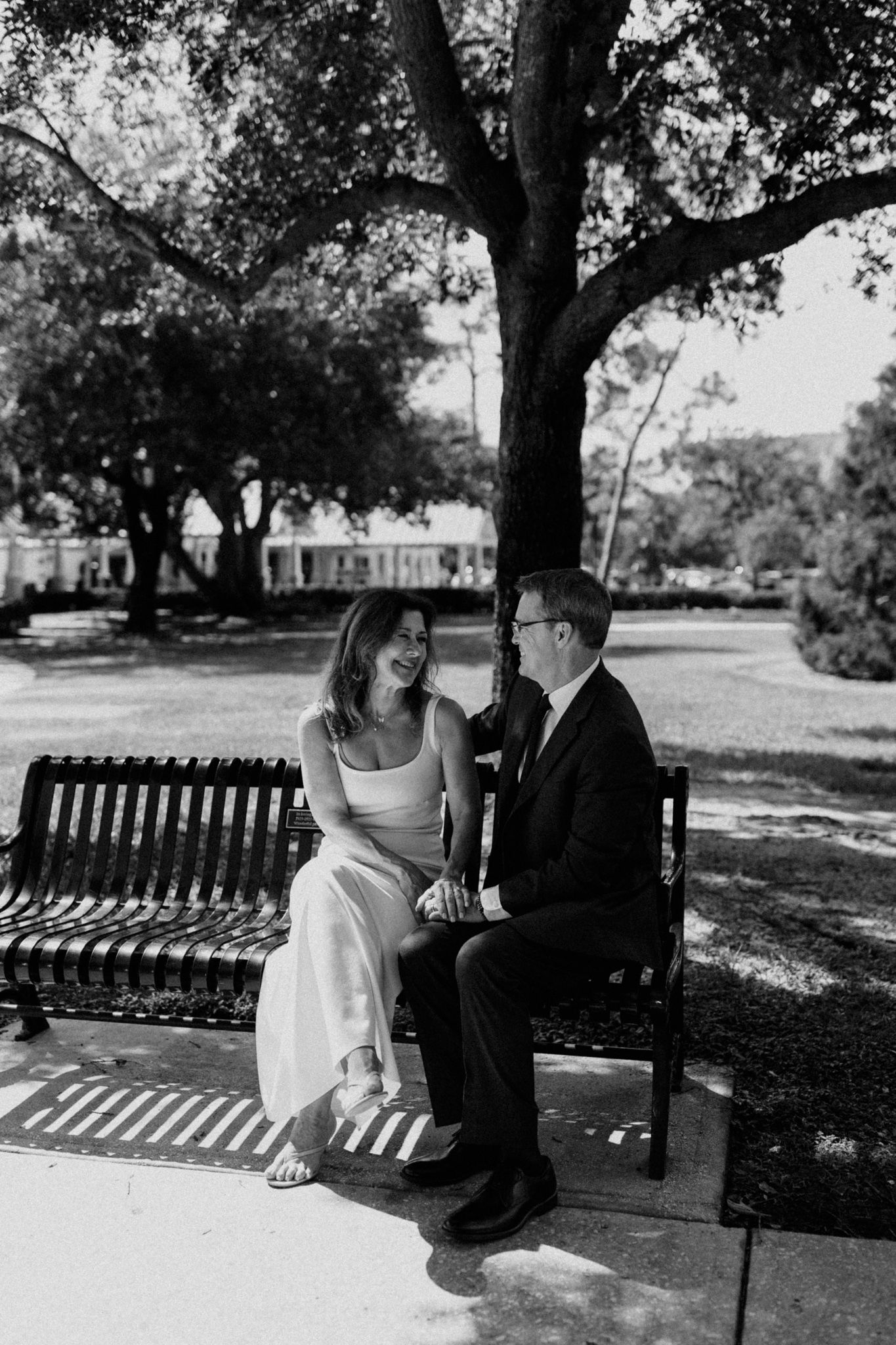Couple shares tender moments on a park bench under shady trees, Orlando Florida