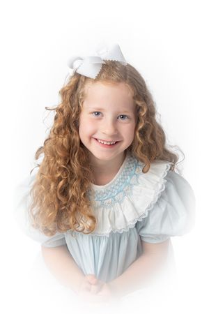 Heirloom photograph of young girl with long curly blonde hair in a blue smocked dress and bow.