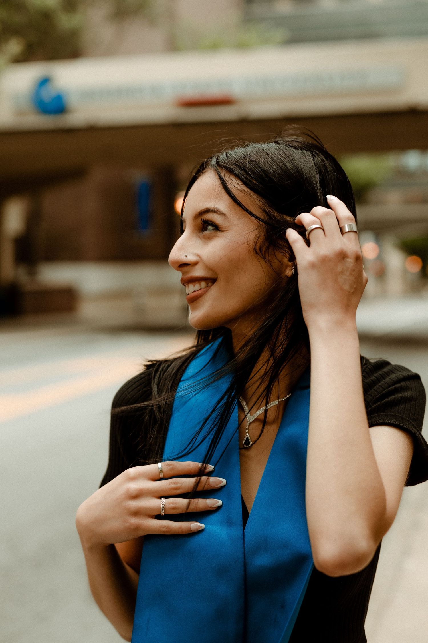 A joyful portrait in a blue outfit with natural lighting in an urban setting.