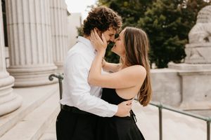 Couple sharing a passionate kiss on stone steps during elegant engagement session.