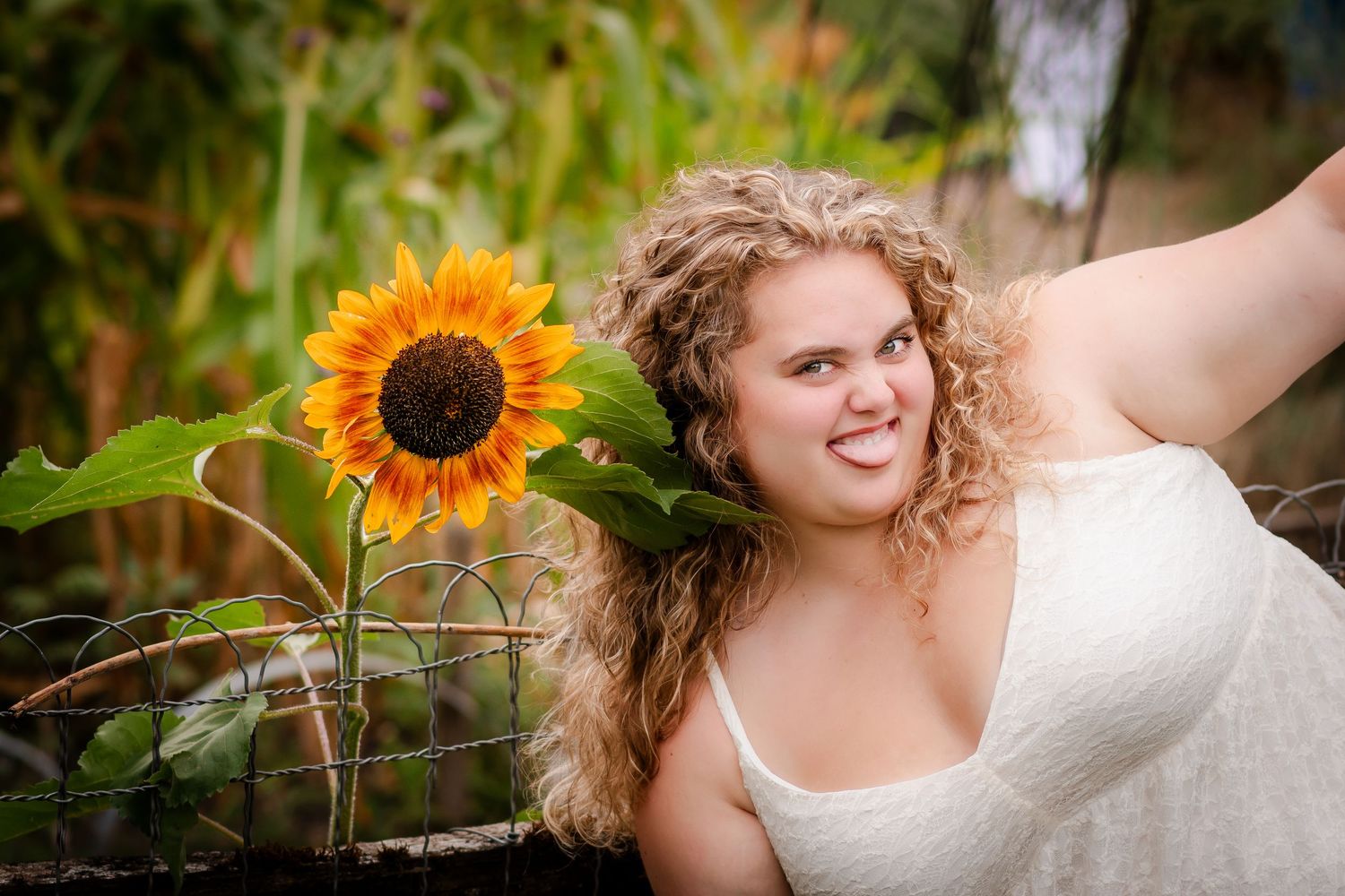 Young child with curly hair spreads arms joyfully in warm sunlight.