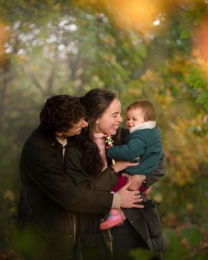 A heart-warming family moment outdoors with warm lighting and autumn foliage in the background.