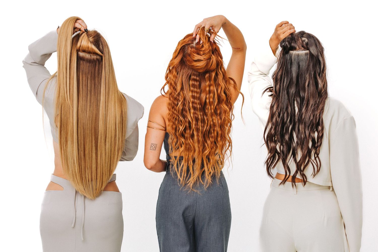 Back view of three women showing different hair colors and textures - straight blonde, wavy red, and curly brown.