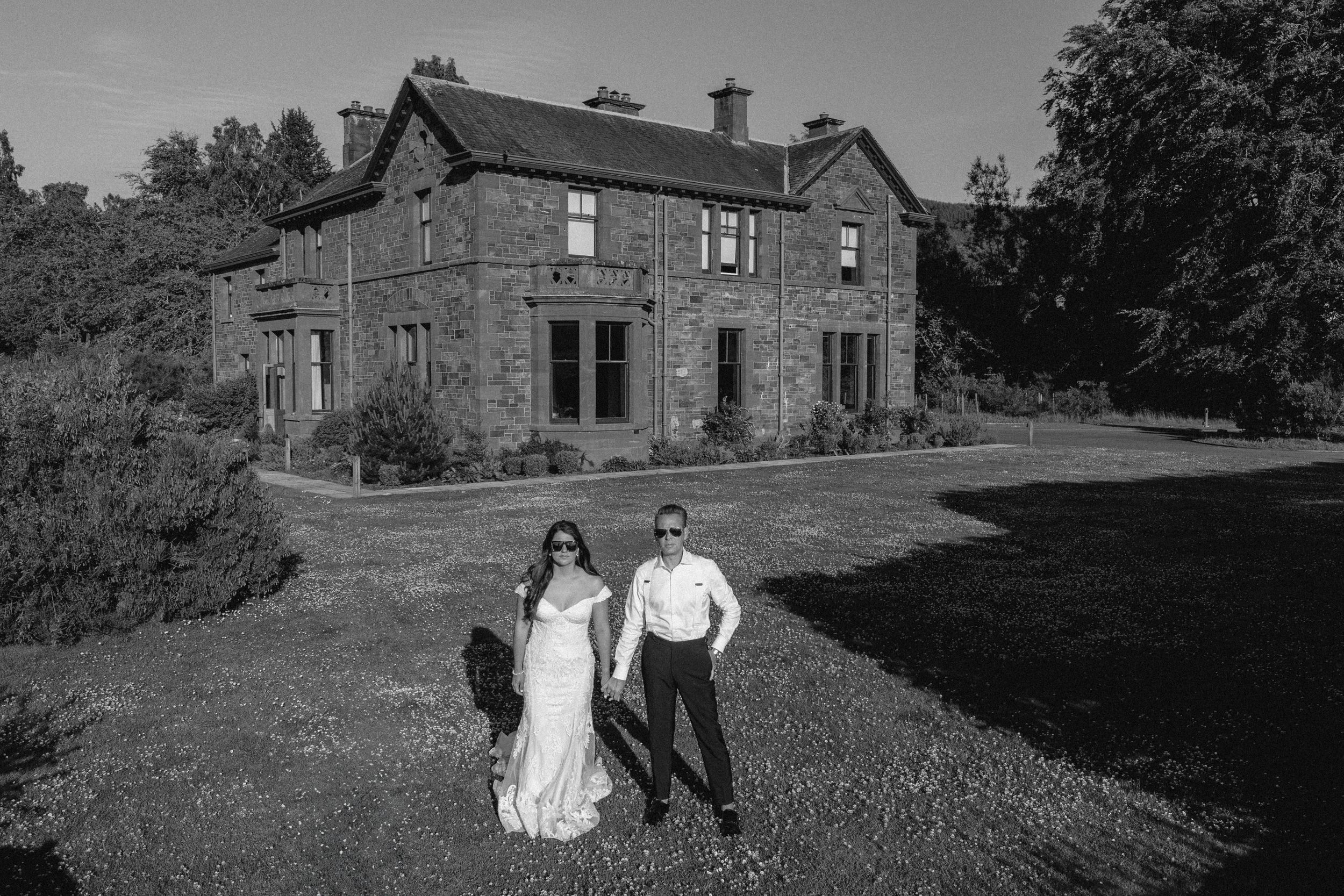 Black and white photo of stone buildings and grounds at a rustic wedding venue.