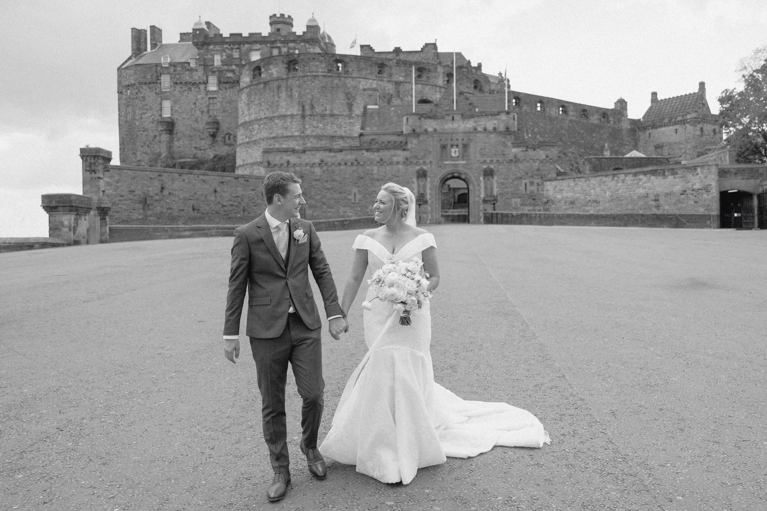 Black and white wedding photos captured against a historic castle backdrop.