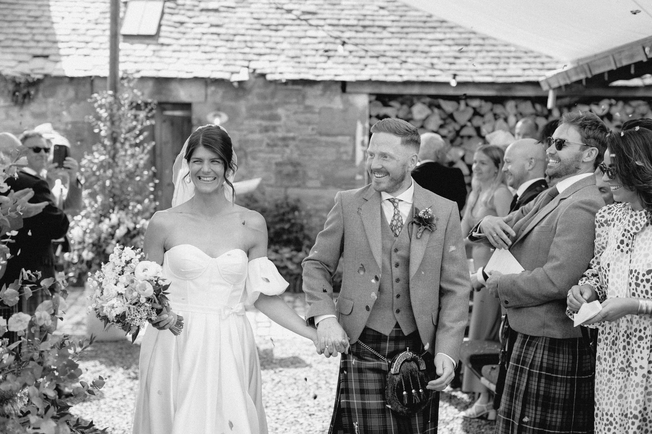 A collection of black and white wedding photographs showing candid moments between couples and guests at outdoor ceremonies.