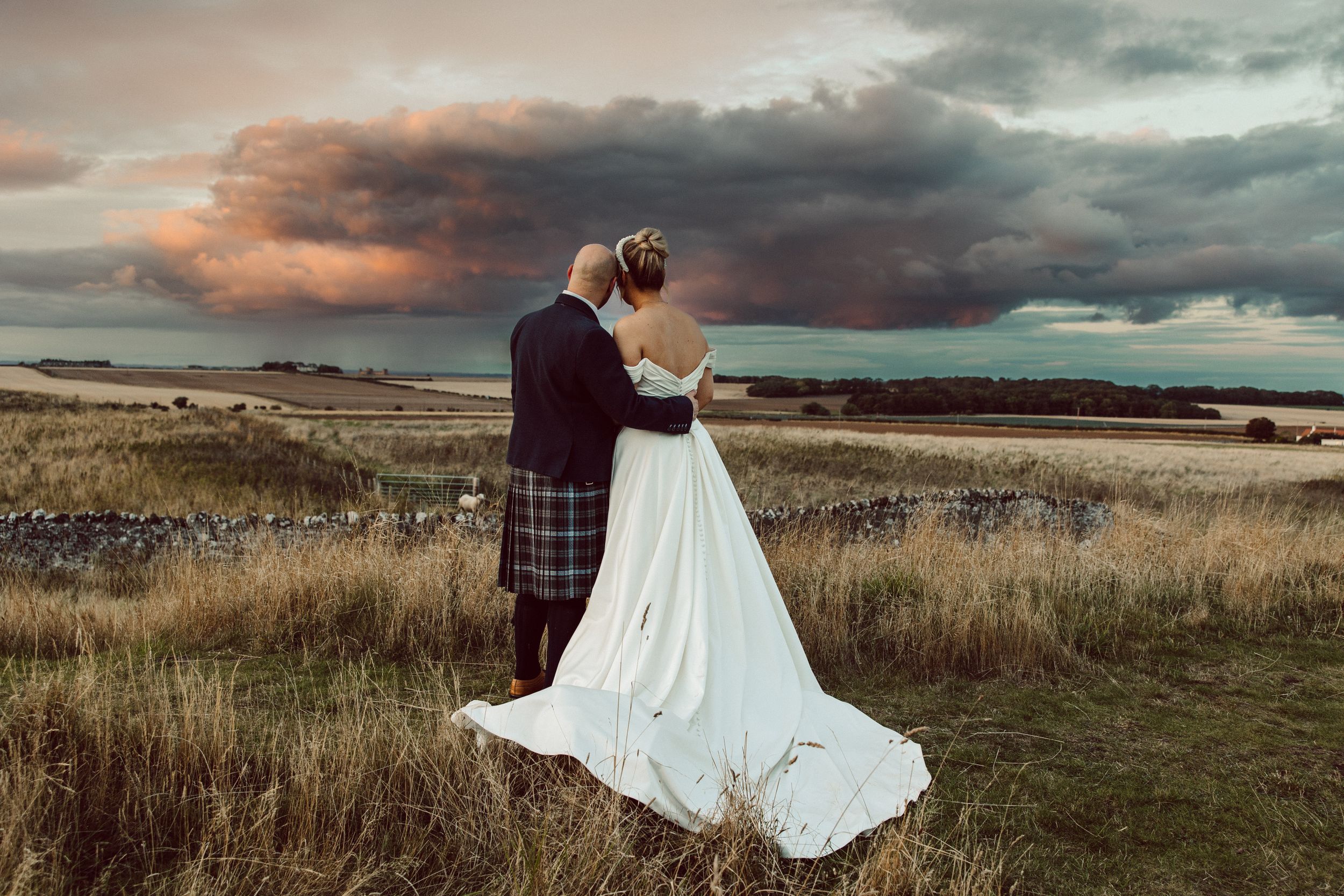 Dramatic sunset wedding photos with moody clouds and sweeping coastal landscapes.