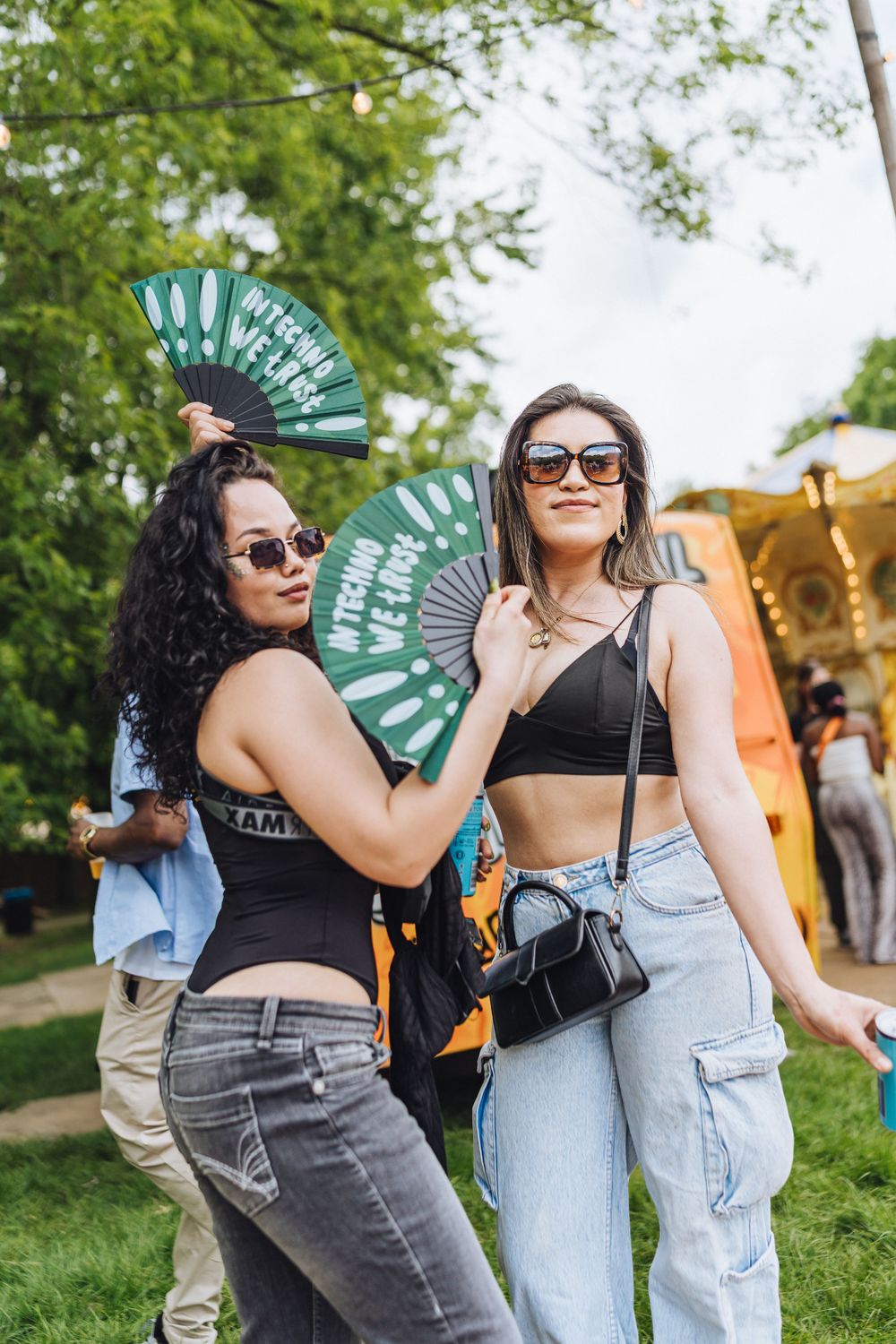 Festival attendees with decorative fans posing outdoors.