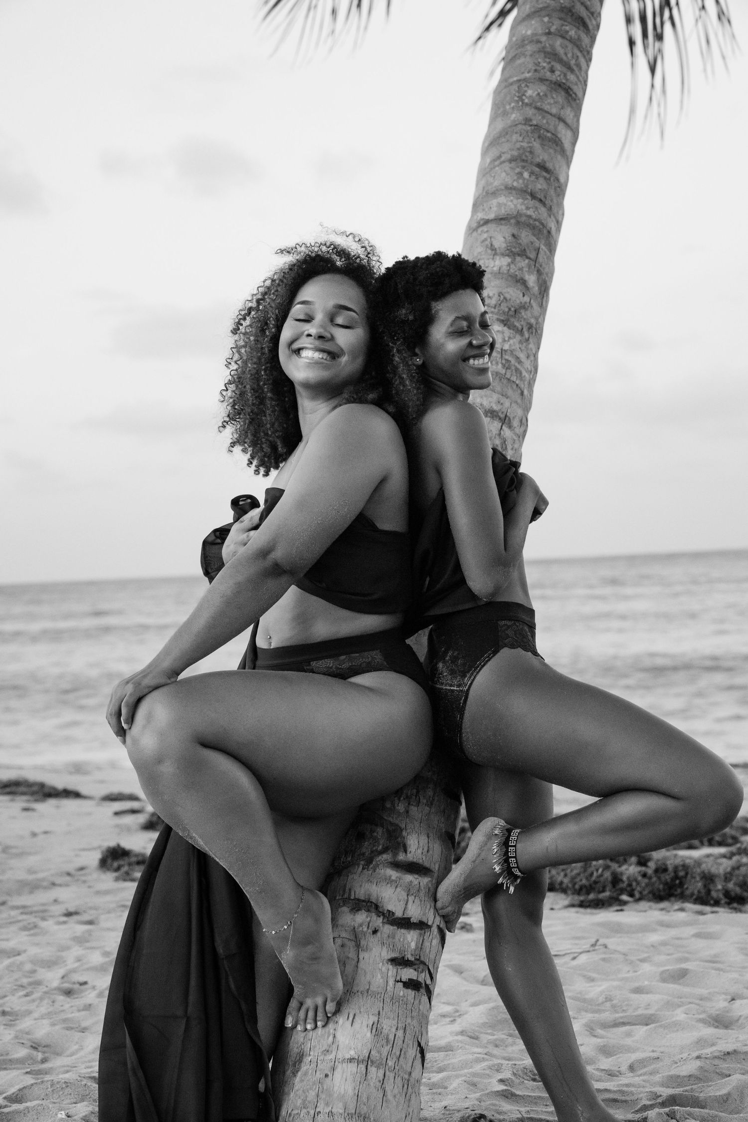 Couple sur la plage près d'un palmier, photographie en noir et blanc