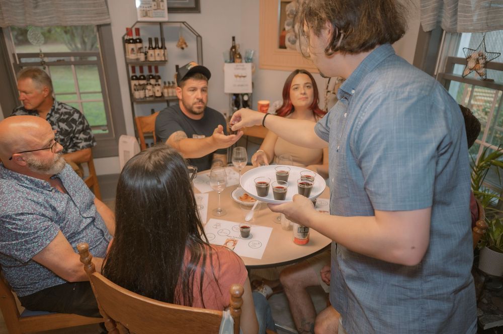 A group of people gathered around a table enjoying drinks and conversation.