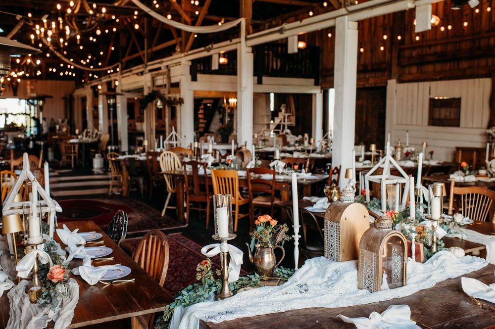 Rustic barn wedding reception venue with twinkling string lights and elegant table settings creating a romantic atmosphere.