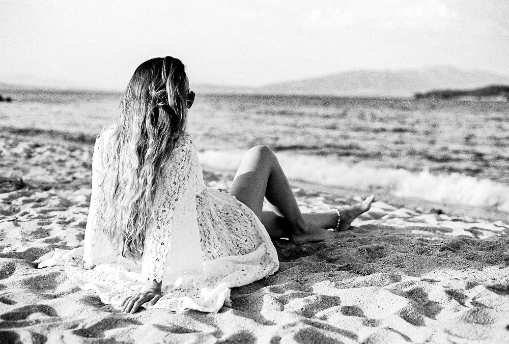 Portrait of a woman contemplating and watching the sea in Chalkidiki, Greece.