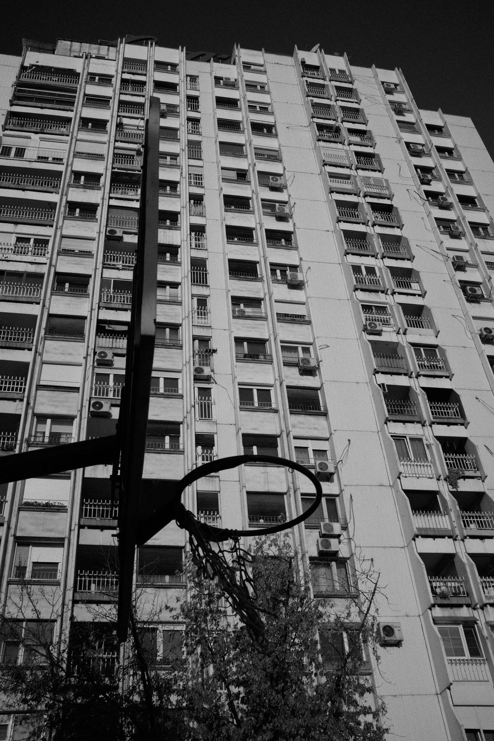A basketball hoop in front of a high riser.