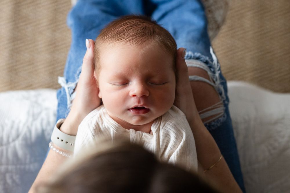 Newborn cradled in a parent's hands during a studio session in Mountain Home, Arkansas