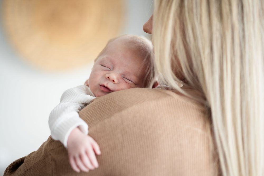 Newborn resting over their mother's shoulder during a studio session in Mountain Home, Arkansas