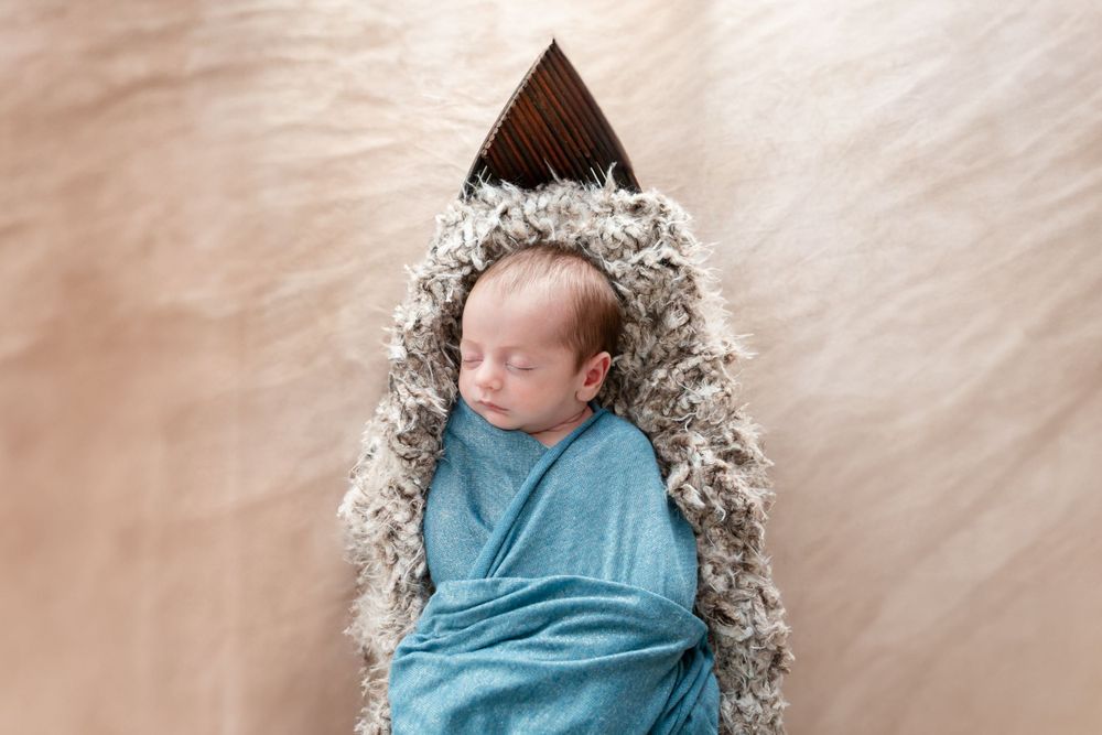 Swaddled newborn in a teal wrap during a studio session in Mountain Home, Arkansas