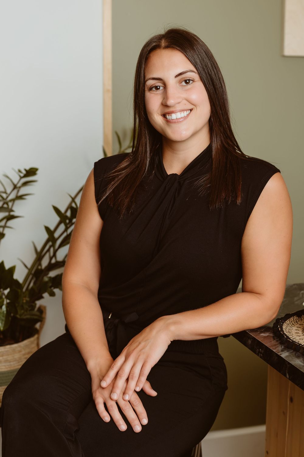 A woman in a black sleeveless dress poses for a series of professional headshots against a neutral background.