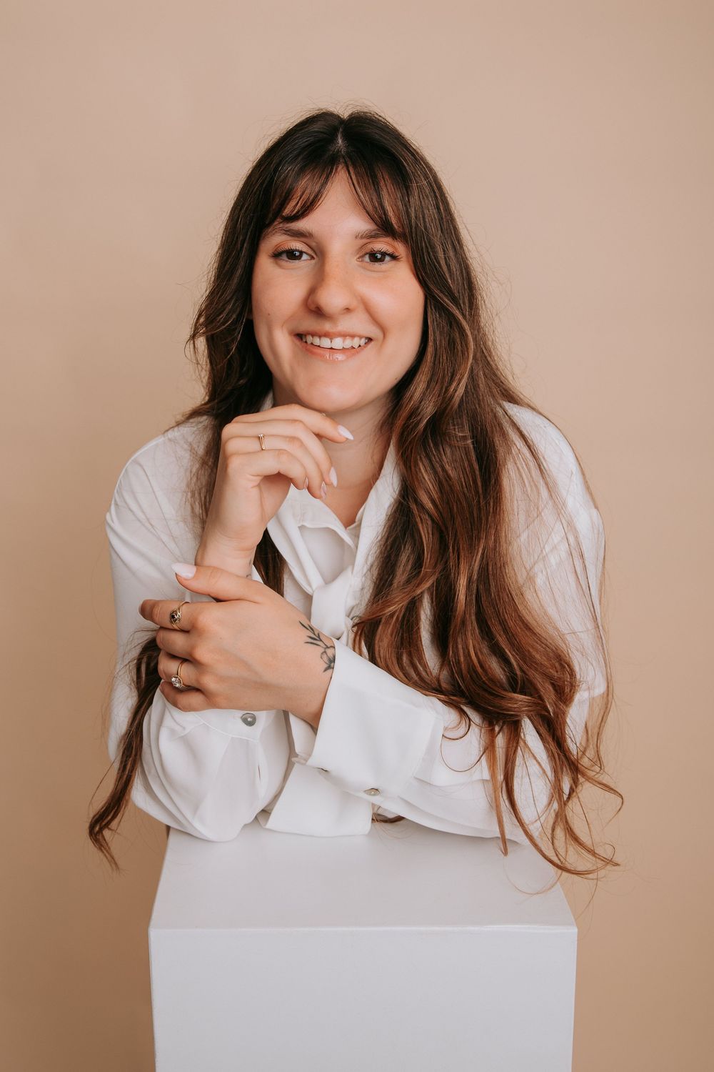 A series of four portraits showing someone in a white button-down shirt against a beige background with playful expressions.