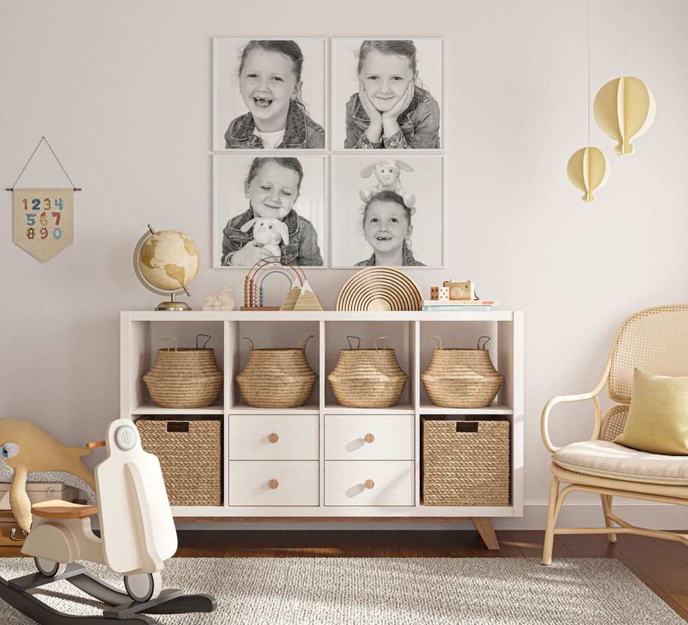 Modern nursery with black and white portraits above a white storage unit with woven baskets.