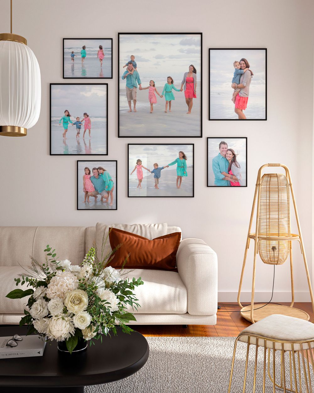 Gallery wall of beach photos in turquoise and pink tones above white sofa with modern lighting fixture.