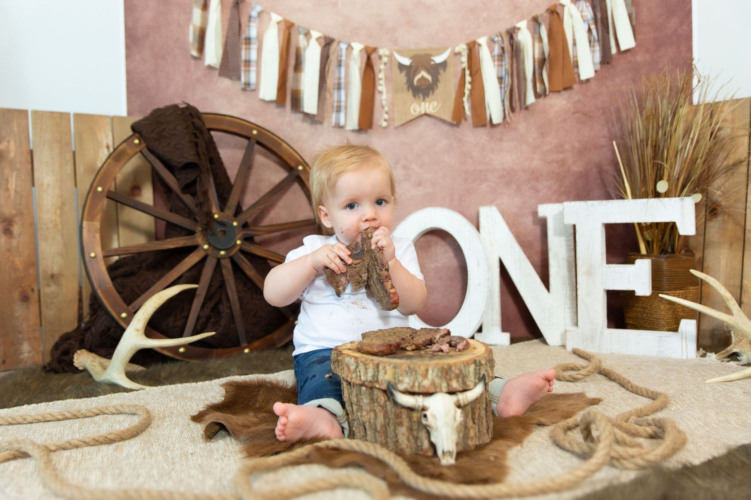 Sweet themed first birthday setup with donut decorations and pink balloon letters against white background.