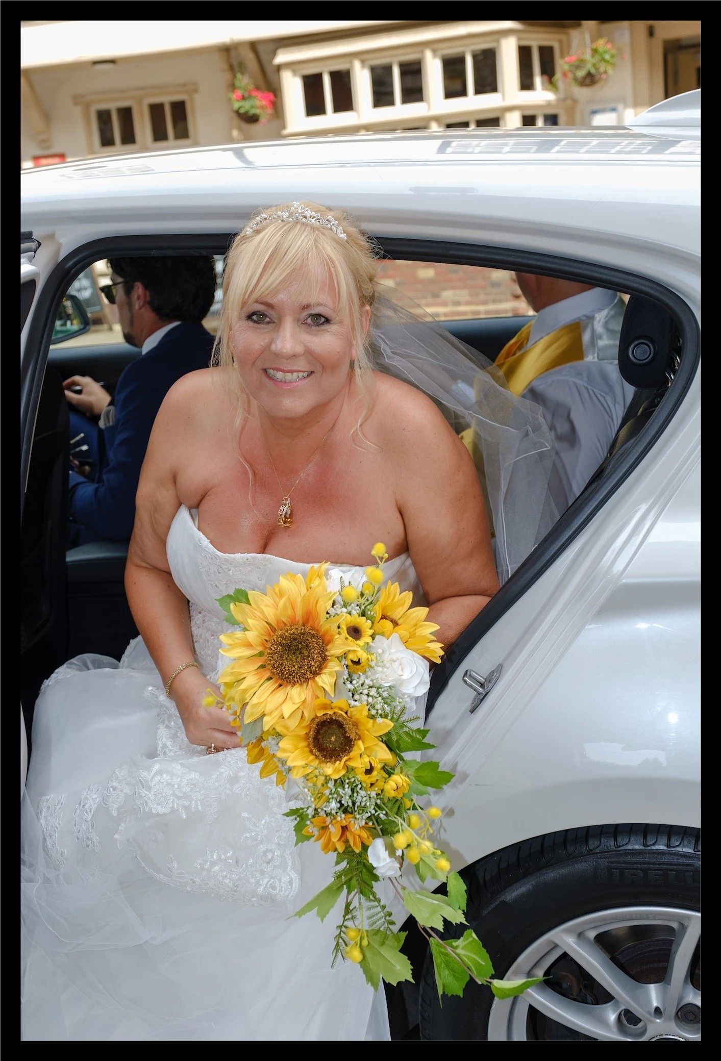 Bride getting out of white car.