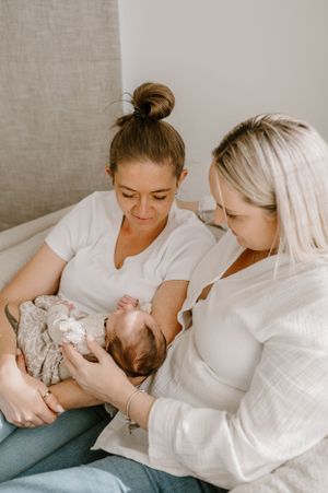 A cozy scene on a sofa as a newborn receives loving attention.