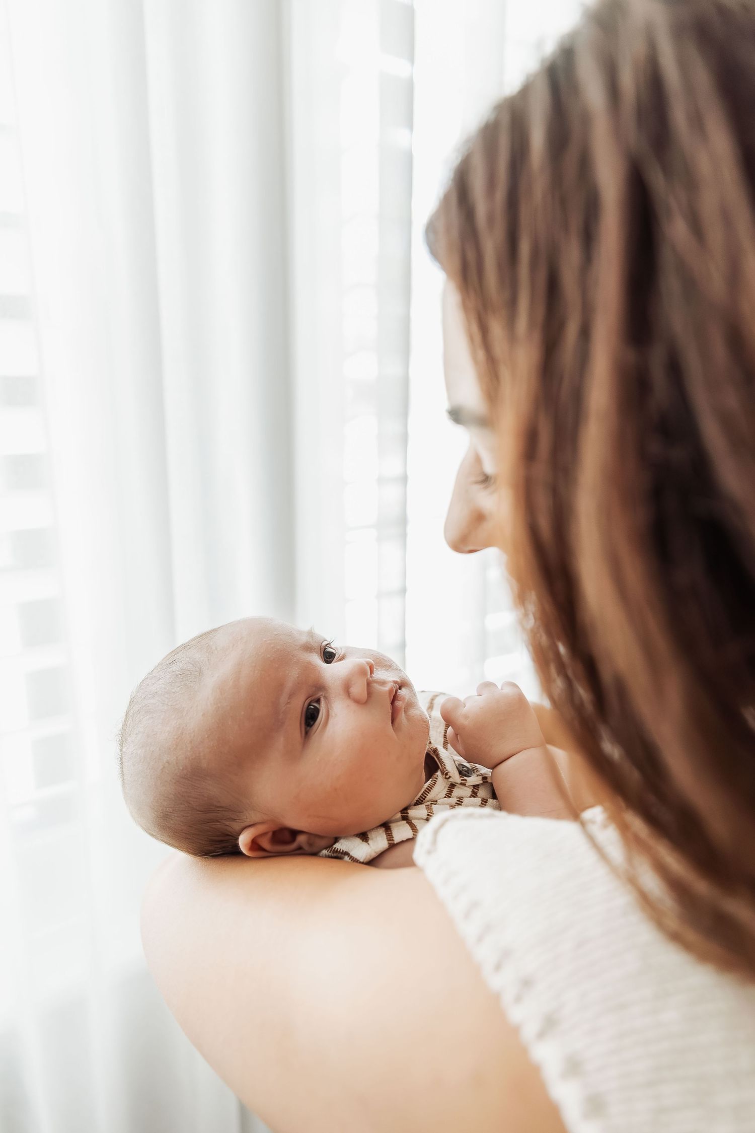 Newborn photography Adelaide — mother holding newborn in natural window light, in-home session Mawson Lakes — Photo By Nancy