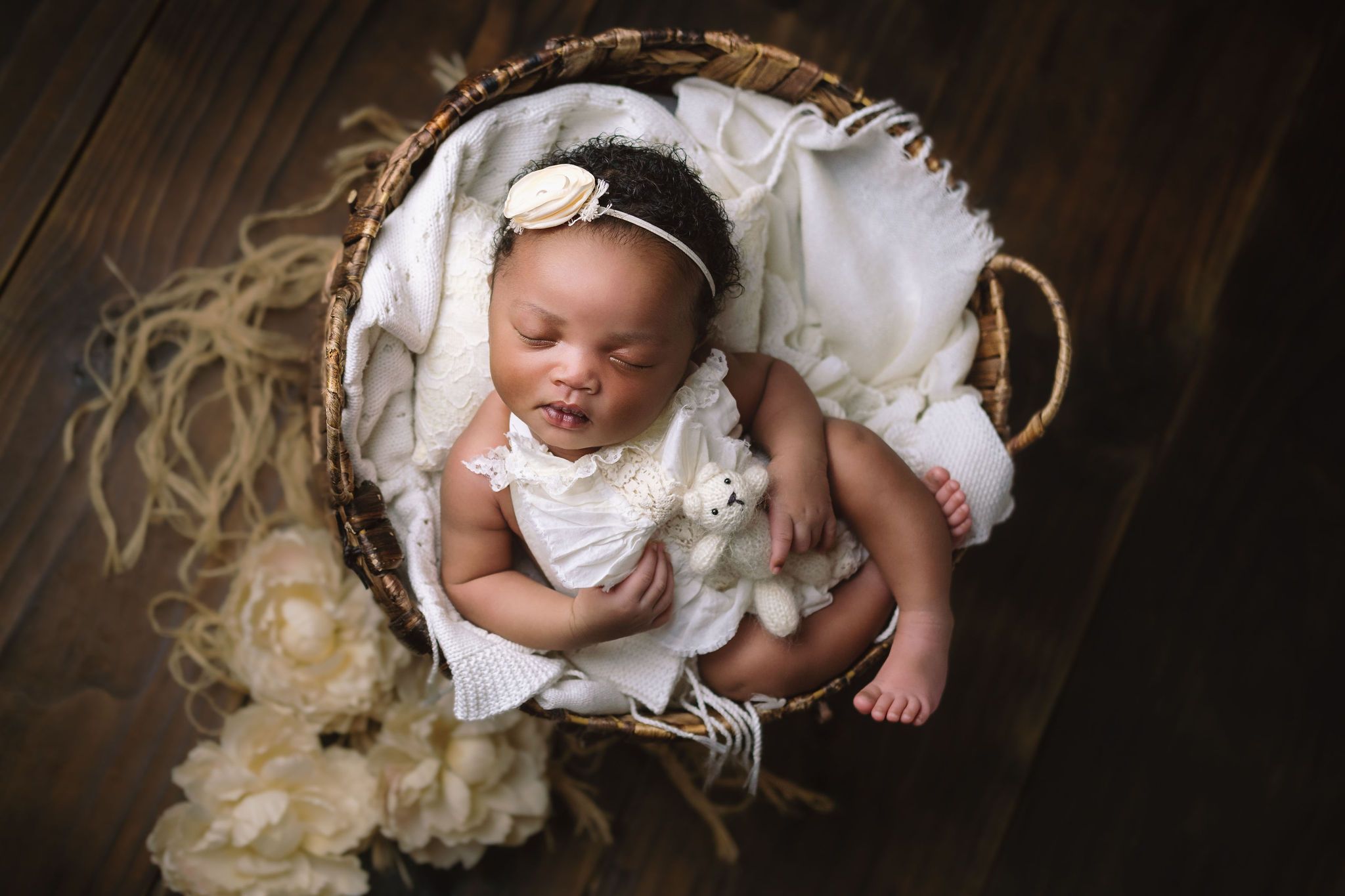 Newborn girl in basket with soft blankets and flowers, Empangeni newborn studio photography