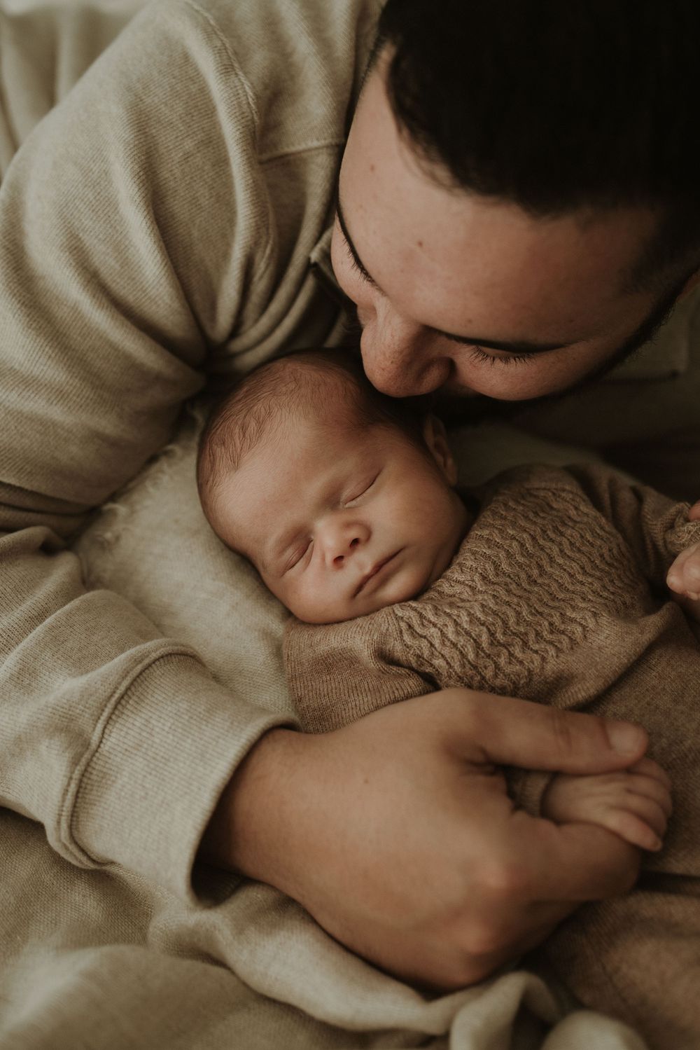 A tender moment captured in warm tones as a parent and child share a peaceful embrace under soft blankets.