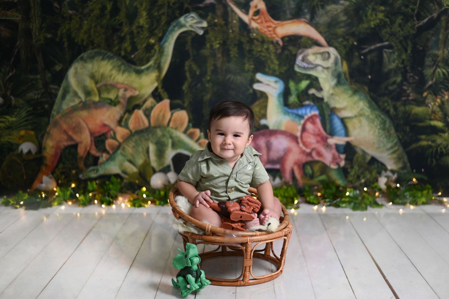 Dinosaur themed birthday party setup with colorful decorations and wooden chairs against a leafy backdrop.