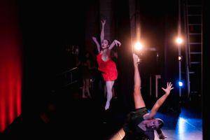 Stage performance featuring dramatic dance lift with theatrical lighting.