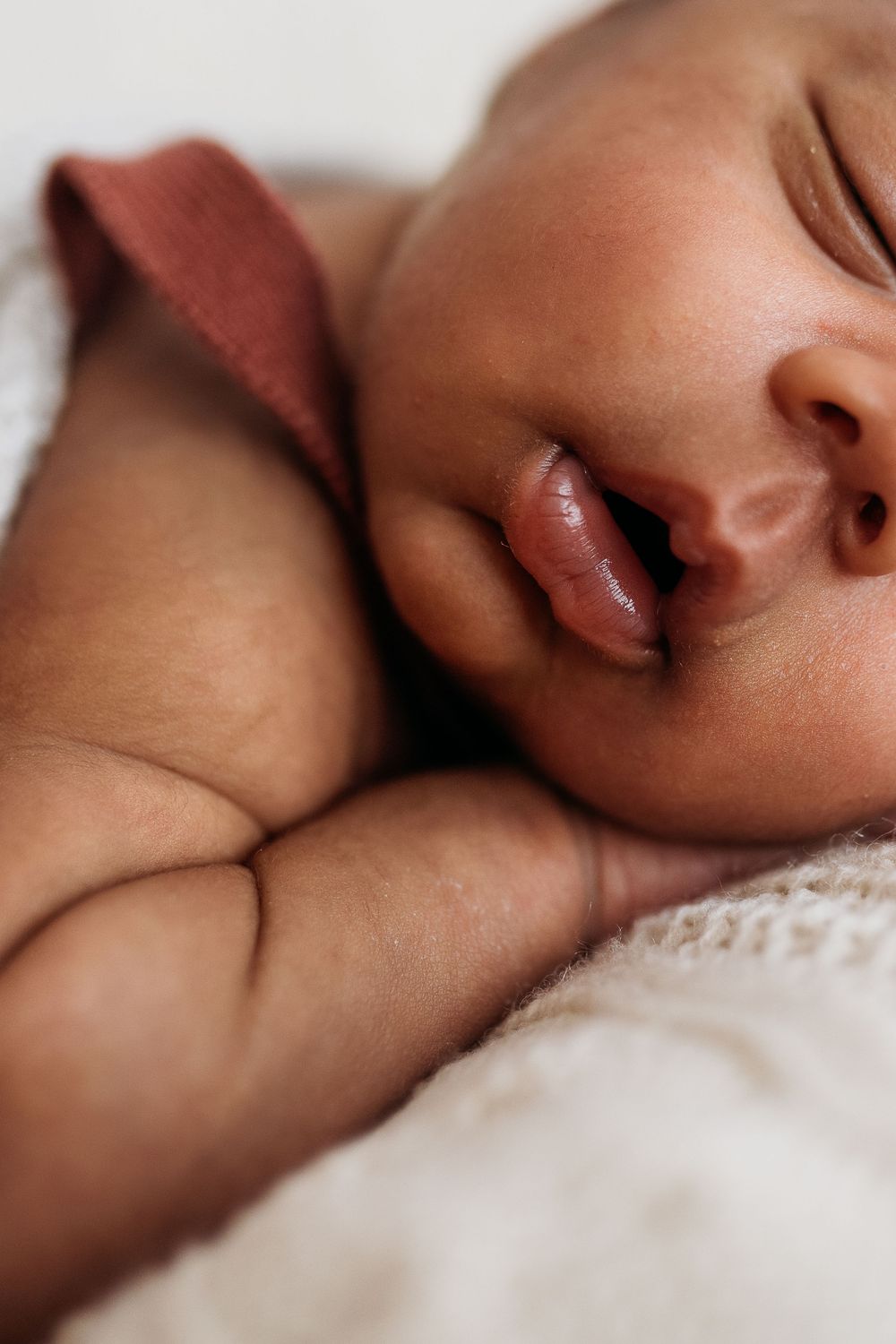 close up of sleeping newborn arms and face.