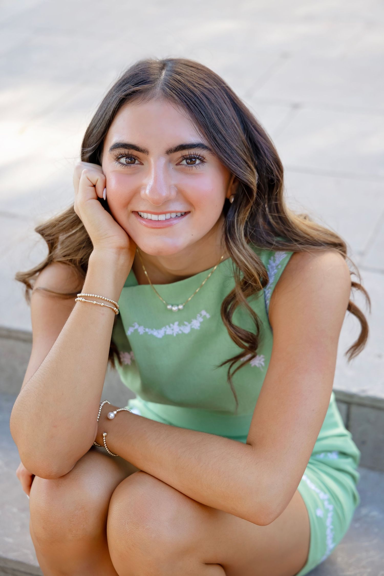 A series of close-up portraits showing a person in a mint green top with long wavy hair and jewelry against a light background.