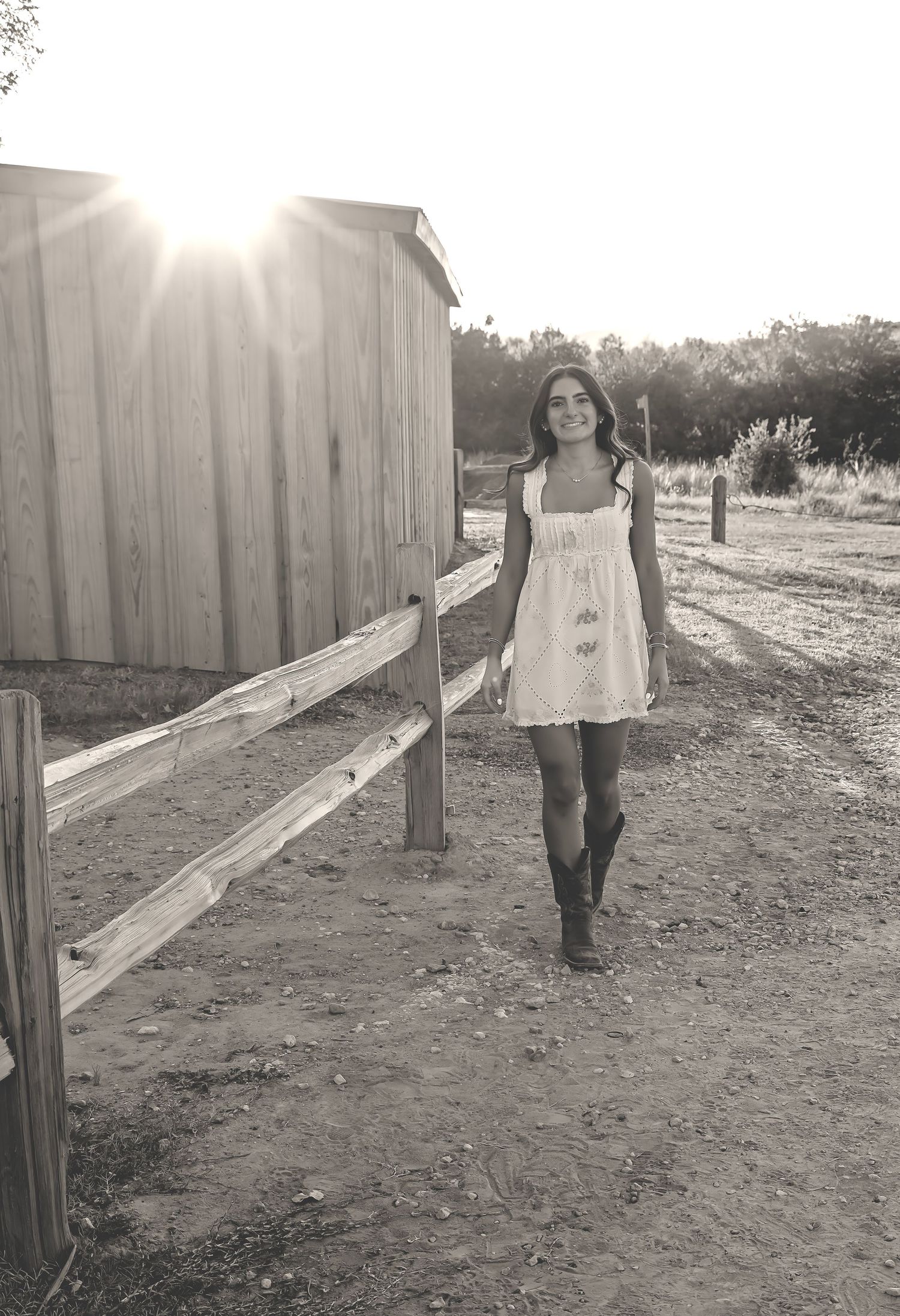 A series of black and white photos showing someone walking along a wooden fence in a rustic outdoor setting at sunset.