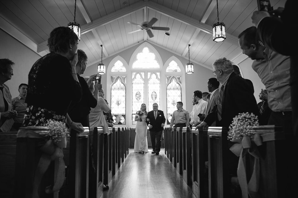 Classic black and white photo of a bride walking down the aisle with her father during a wedding ceremony in Philadelphia