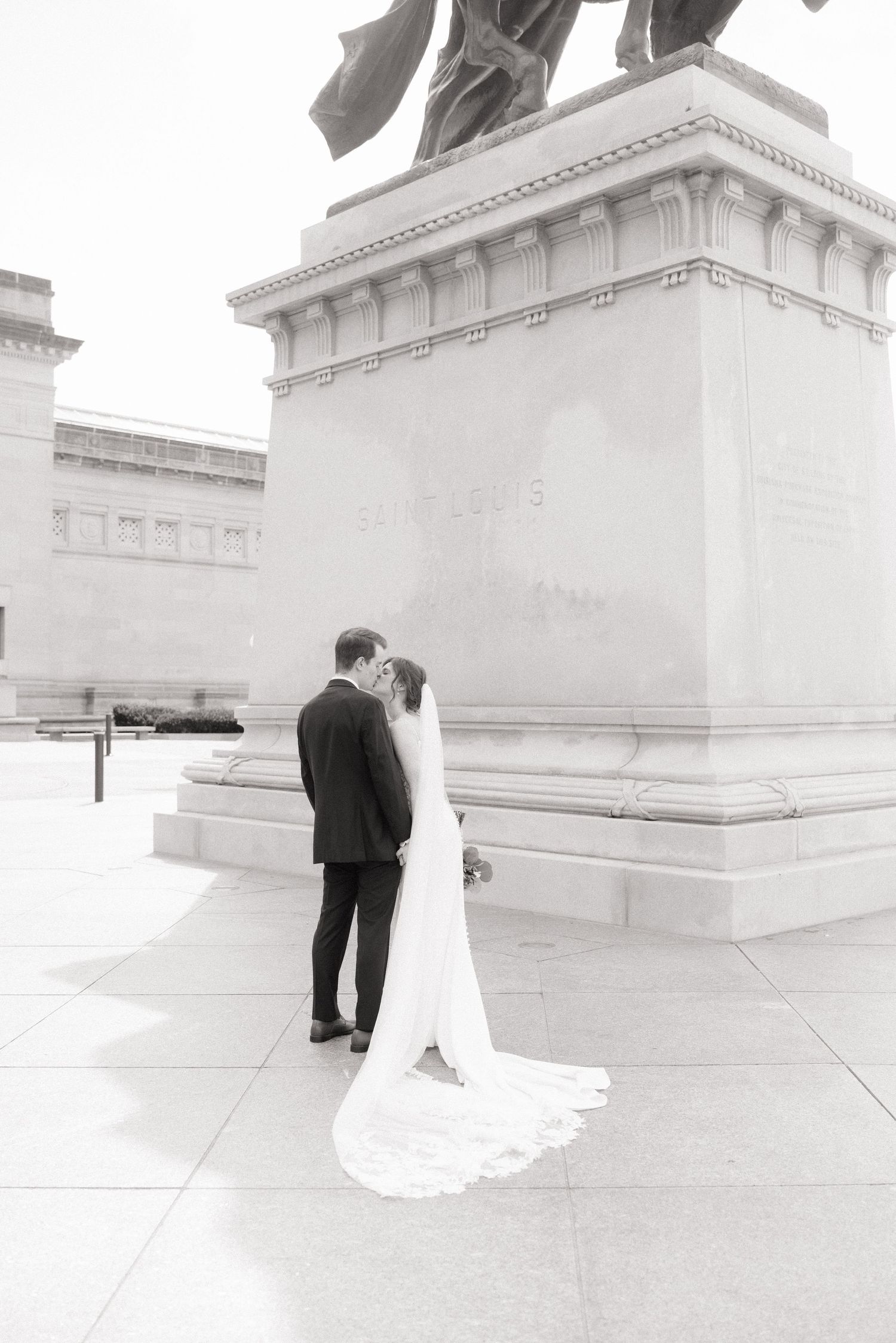 Black and white wedding photos showing a couple walking together on a path with the bride's dress trailing behind.