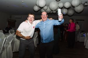 People dancing and celebrating at a party decorated with white paper lanterns.