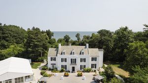 A panoramic aerial view of a coastal resort property with multiple white buildings and lush green landscaping.