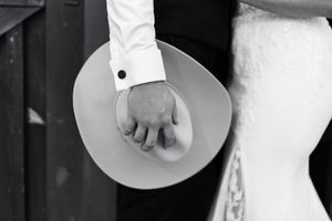 Black and white wedding detail shots show elegant formal attire with white shirts, cufflinks and dress accessories.